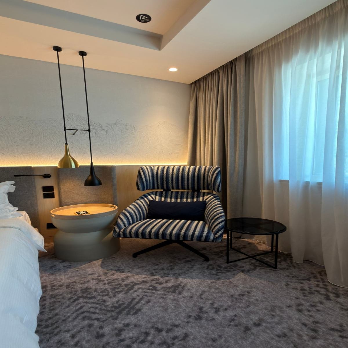 Cozy modern bedroom reading corner with an accent chair, side table, and floor lamp