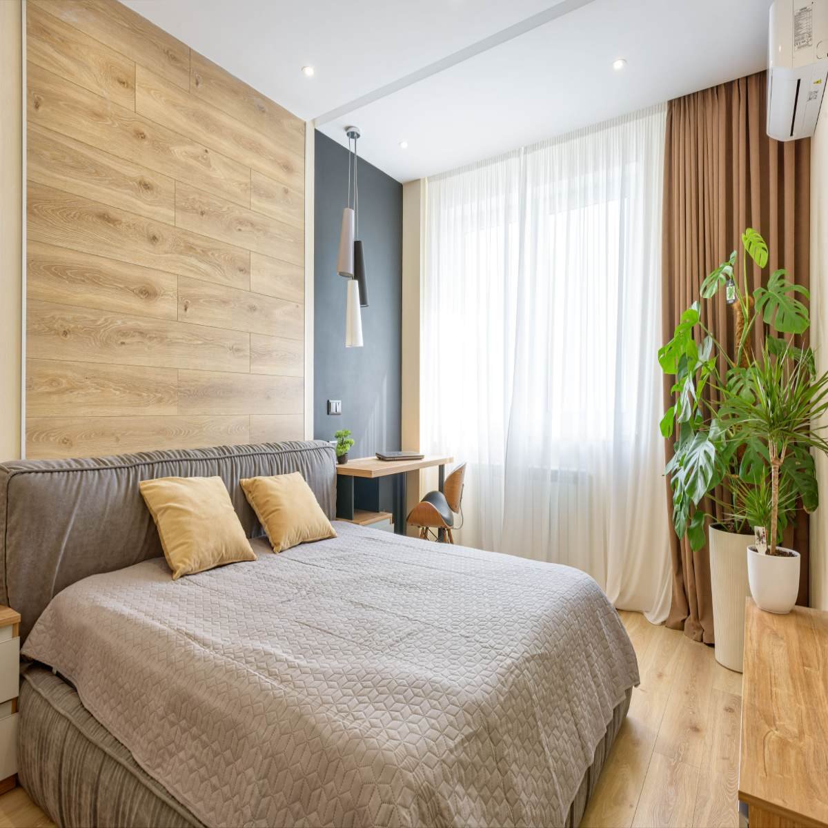 Modern bedroom with floor-length curtains, neutral decor, and soft natural light