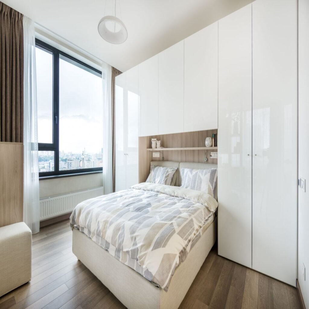 Small apartment bedroom with a low bed, compact furniture, and a clean modern layout