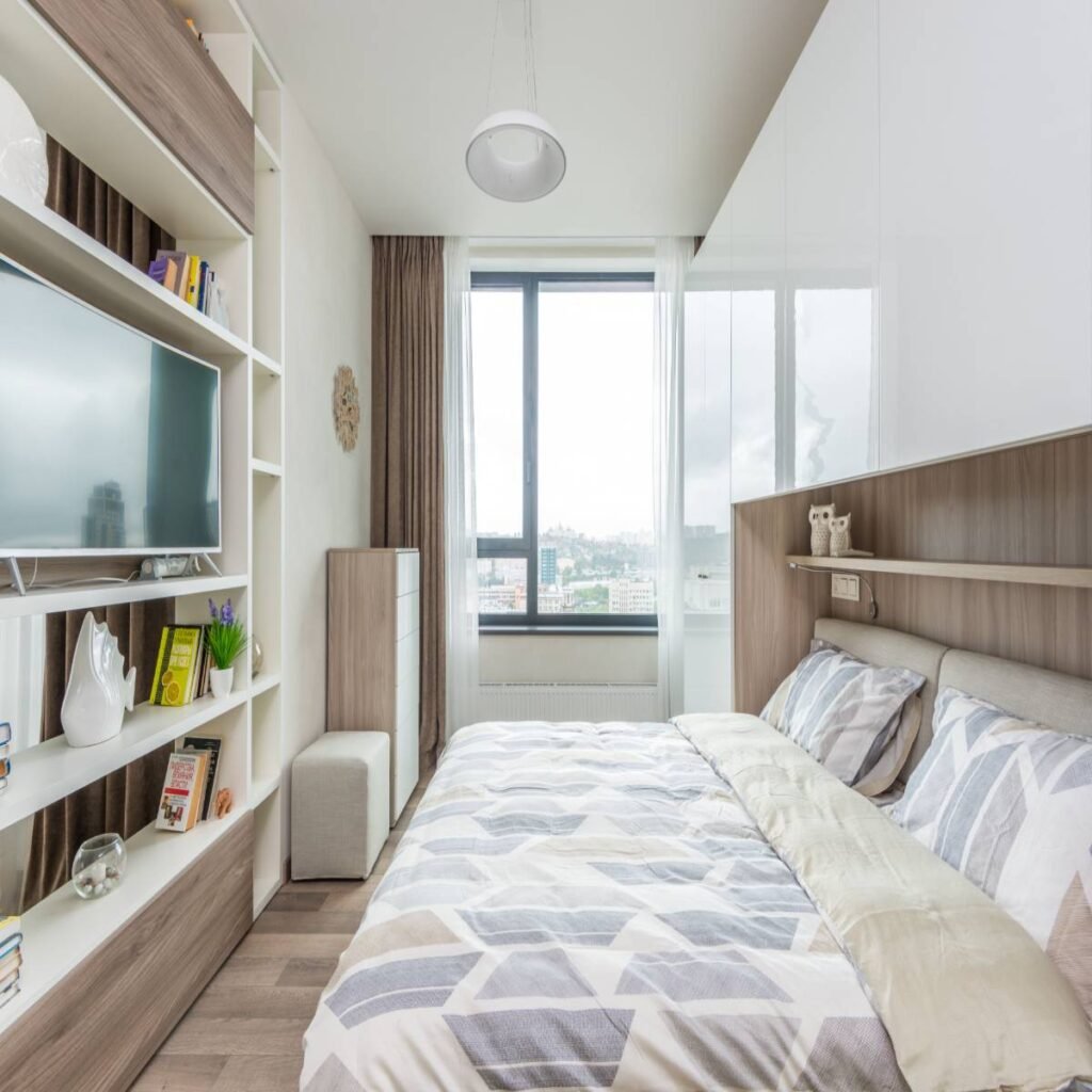 Cozy small apartment bedroom with textured bedding, cushions, a soft rug, and simple modern decor