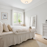 elegant minimal rental friendly small bedroom with white bedding plants and natural light