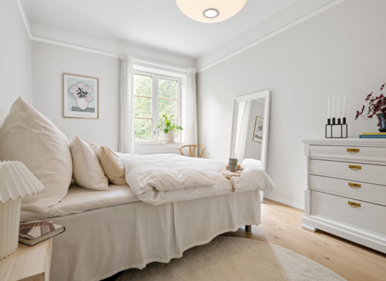 elegant minimal rental friendly small bedroom with white bedding plants and natural light