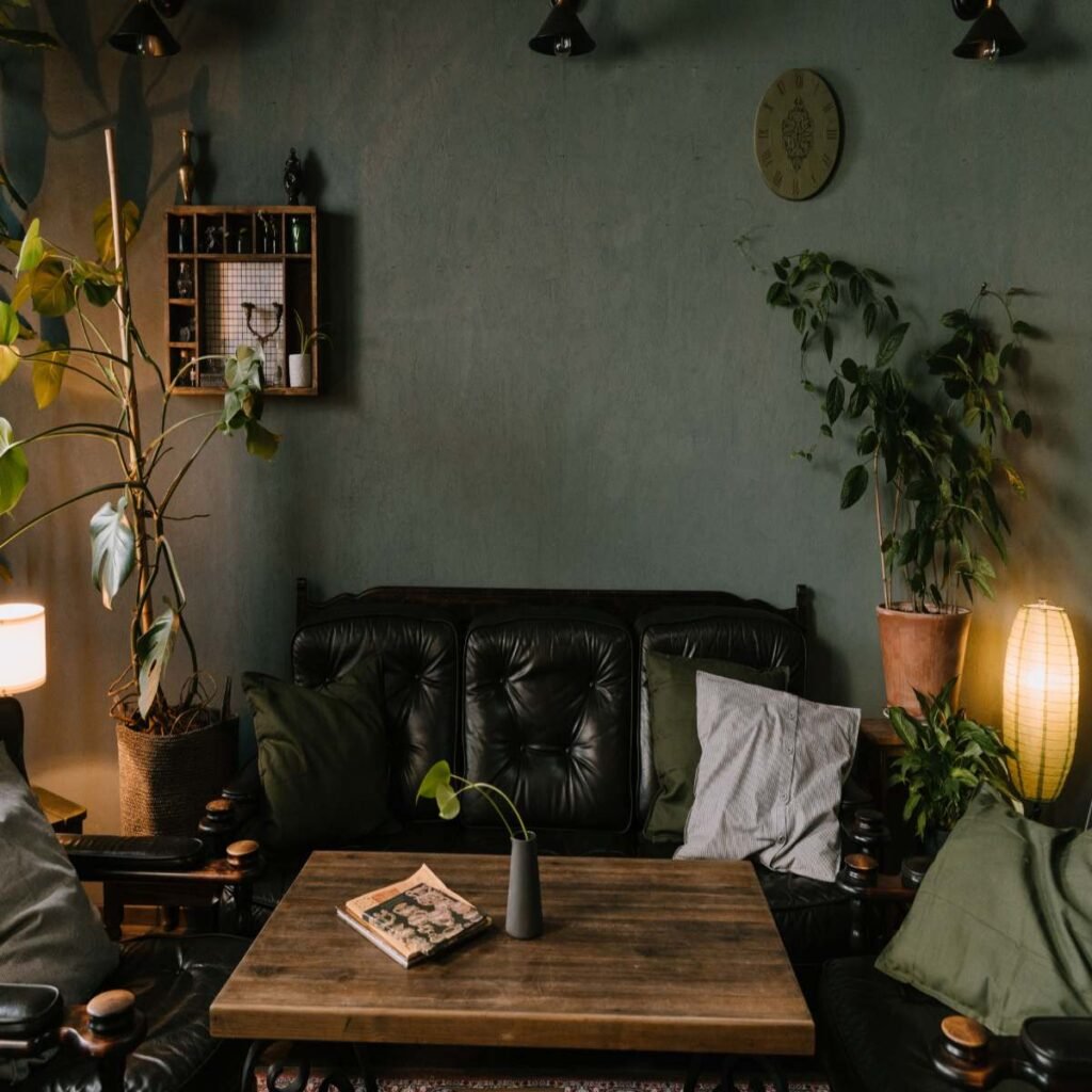 Dark boho living room with a cozy sofa, textured pillows, and a soft throw blanket